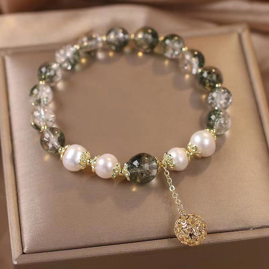 Green Phantom Pearl Charm Bracelet – Green quartz white pearls gold spacers with filigree pendant on beige satin cushion in jewelry box, 45-degree elevated