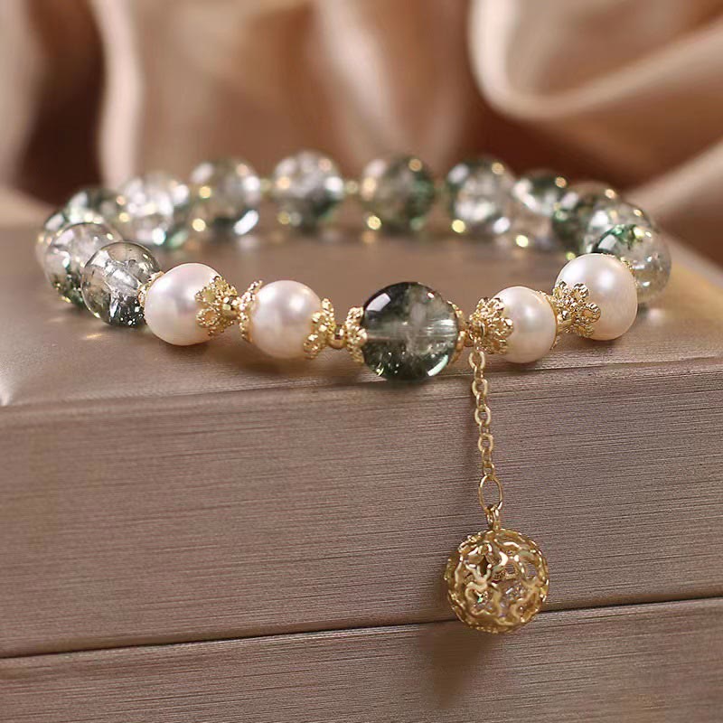 Green Phantom Pearl Charm Bracelet – Green phantom quartz white pearls gold floral spacers with filigree ball dangle, wood surface champagne silk, low side
