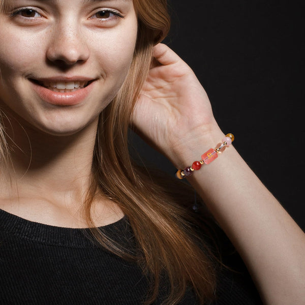 Zodiac Crystal Bracelet – worn on wrist of model, Libra symbol visible on pink bead