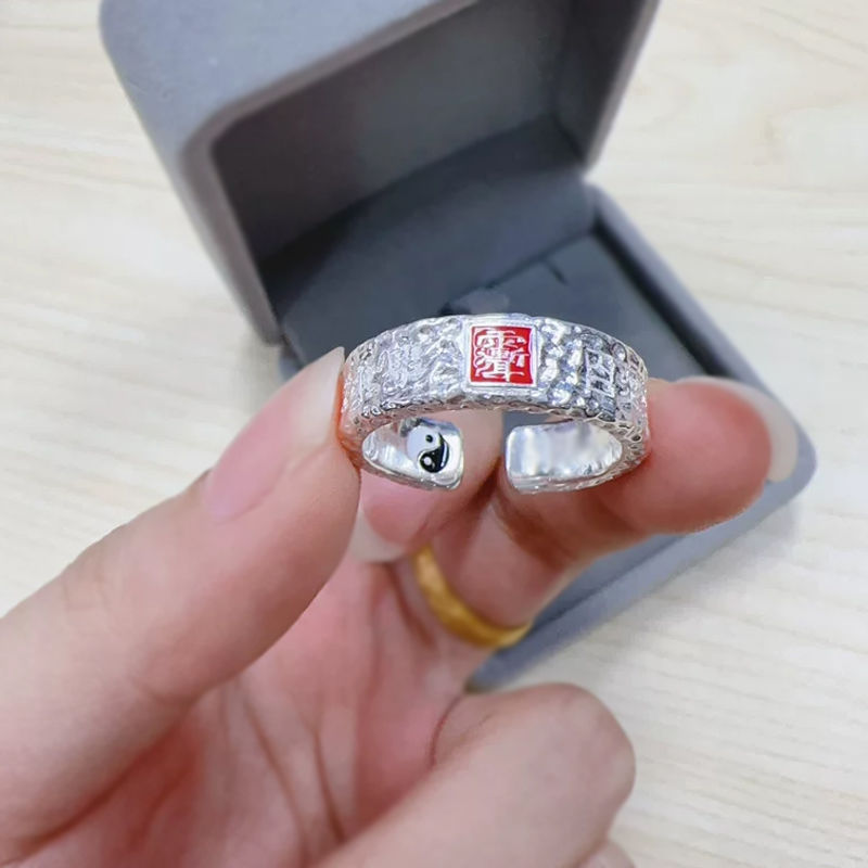 Tian Guan Ci Fu Ring – hand holding silver ring near gray velvet jewelry box, blessing protection amulet ring