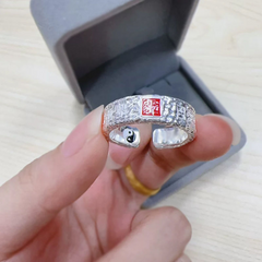 Tian Guan Ci Fu Ring – hand holding silver ring near gray velvet jewelry box, blessing protection amulet ring