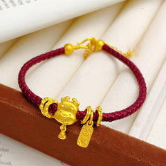 Ben Ming Nian Bracelet – gold dragon charm with small bell, deep red woven band, zodiac accessory