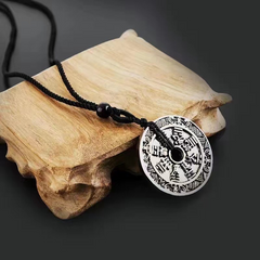 Antique Shan Gui Pendant – silver coin pendant on driftwood with black braided cord, dark gray background, antique mountain ghost charm