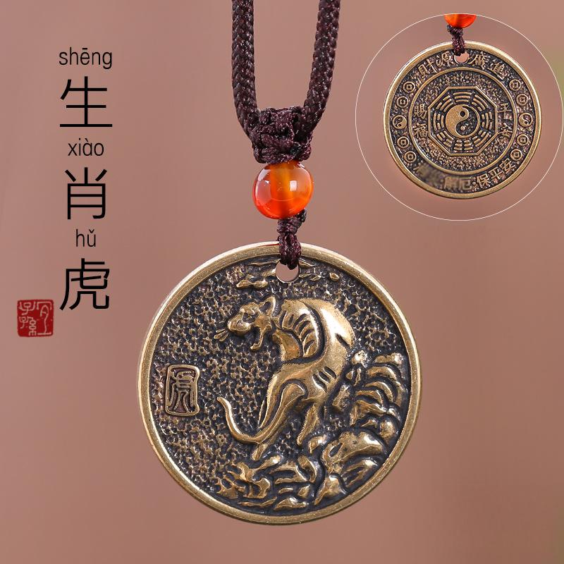 Zodiac Bagua Pendant – brass tiger disc with mountain relief, brown necklace cord, talisman gift
