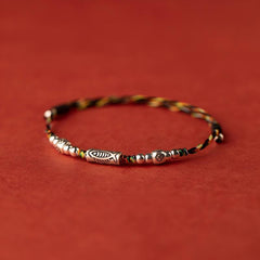 Koi Red String Bracelet – black and gold braided rope with silver koi fish charm on red backdrop, adjustable bracelet