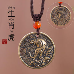 Zodiac Bagua Pendant – brass tiger disc with mountain relief, brown necklace cord, talisman gift