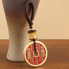 Vajra Knot Shan Gui Keychain – red brass coin amulet with brown cord by ceramic vase, wooden backdrop, spiritual protection keychain
