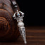 Tibetan Dorje Vajra Rotatable Pendant – Antiqued silver with turquoise inlays, lotus motifs and Sanskrit engravings on dark cord, dark wood vessel backdrop
