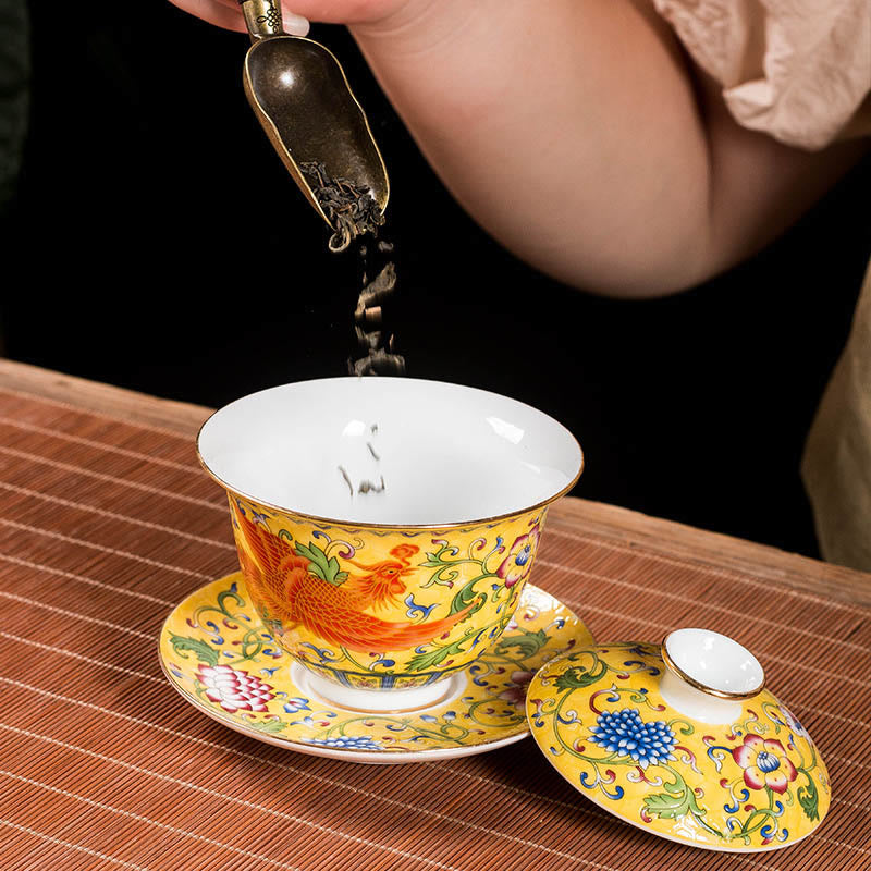 Dragon Phoenix Flower Gaiwan Tea Set – Yellow gaiwan with tea leaves scooped by brass cha-ze, oolong pouring in