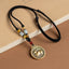 12 Chinese Zodiac Fortune Necklace Pendant – Rabbit zodiac medallion pendant in antique gold brass with raised rabbit relief, Greek key border, black braided cord with jade amber and carnelian beads, warm tan background, lunar new year jewelry gift
