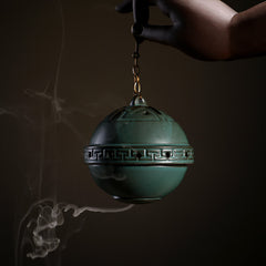 Tibetan Lotus Ceramic Incense Burner – close-up green sphere censer with Greek key band in hand, Meditative