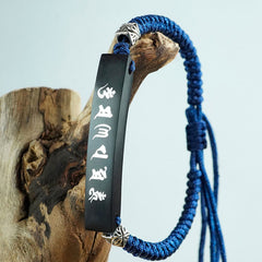Silver Inlaid Protection Bracelet – Hanging on driftwood showing blue cord and black mantra bar
