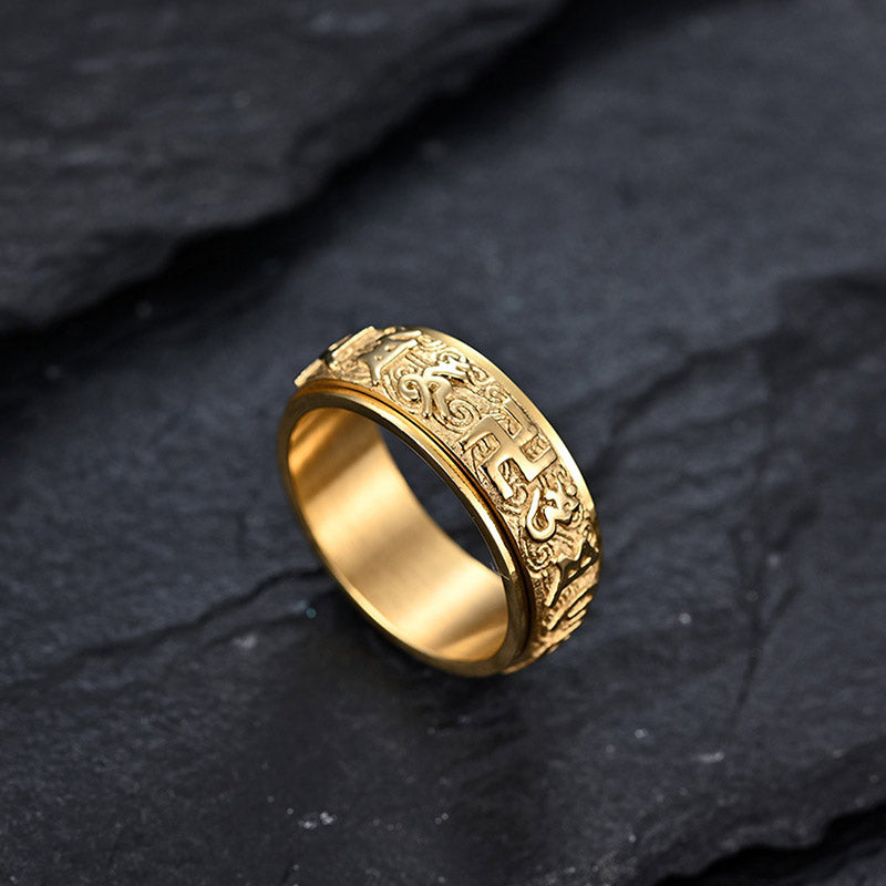 Om Mani Padme Hum Ring – gold spinner band with intricate mythical creature engraving on slate, statement ring