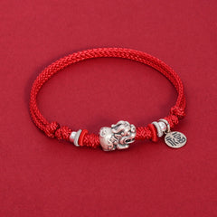 925 Silver PiXiu Fu Bracelet – Red braided cord bracelet with silver PiXiu charm on red surface