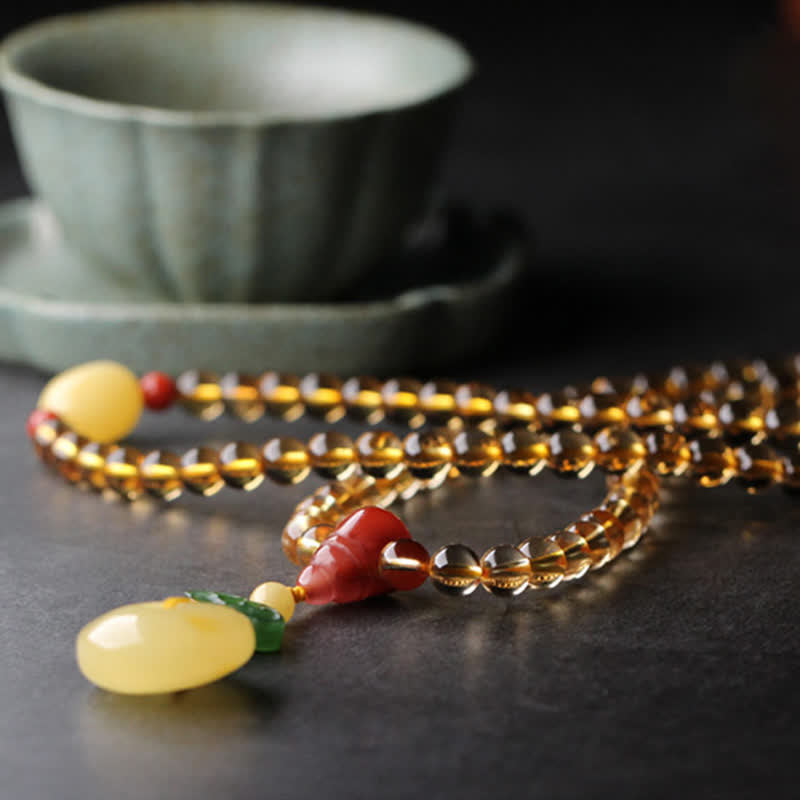 Citrine Mala Bracelet – Close-up of citrine mala with calligraphy scroll, red agate bead detail