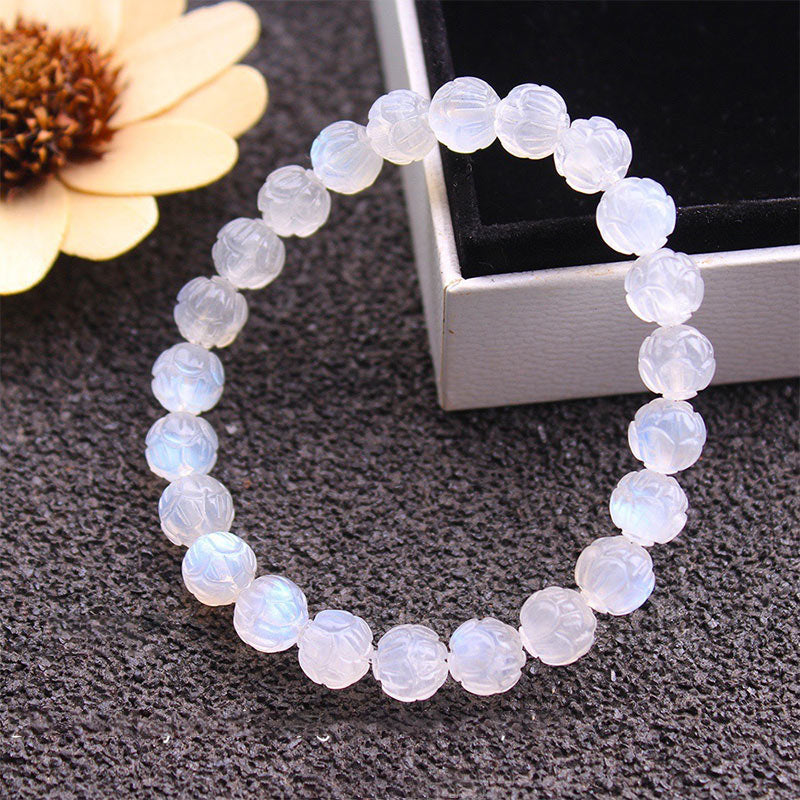 Natural Moonstone Lotus Love Bracelet - draped over silver box with dried flower, carved stone