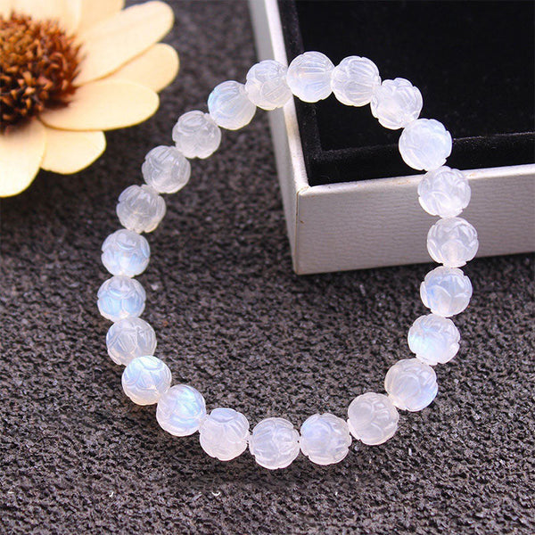 Natural Moonstone Lotus Love Bracelet - draped over silver box with dried flower, carved stone