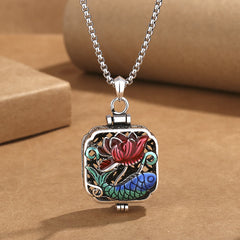 Koi Fish Lotus Ghau Prayer Box Necklace – locket from angle on kraft paper, red lotus blue koi filigree detail