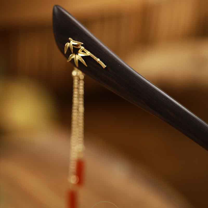 Close-up of hairpin head with gold bamboo leaf inlay and beaded chain