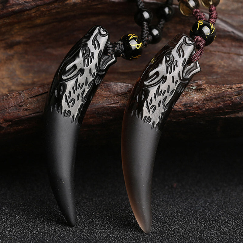 Ice obsidian wolf tooth pendant necklace pair featuring hand-carved wolf head on black obsidian fang with gold-inscribed mantra bead and adjustable braided cord in black and burgundy Hauptbild