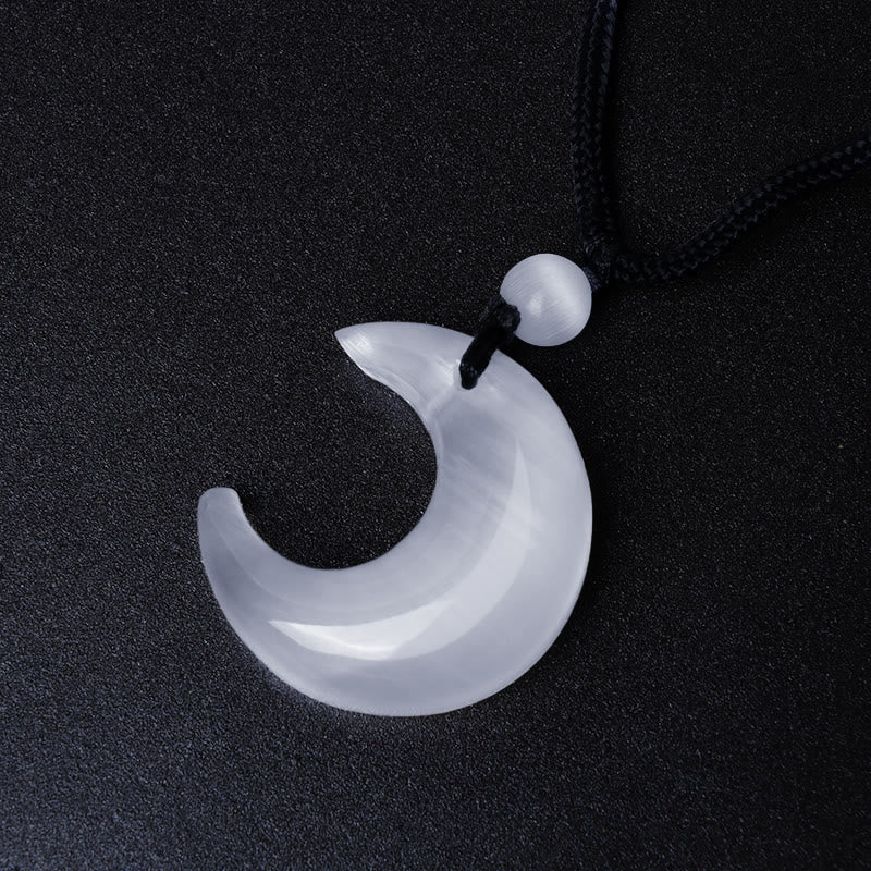 Silver Sheen Obsidian Yin Yang Pendant - White crescent moon with dramatic low-key lighting, crystal jewelry