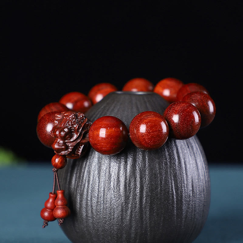 Multi-Wood Dragon Bracelet - Polished red beads with lion carving on ribbed ceramic vessel, Resilience