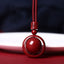 Cinnabar PiXiu Necklace – Front close-up red bead in circle pendant with mantra carving, cinnabar blessing jewelry