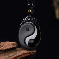 Black Obsidian Yin Yang Pendant Necklace – Obsidian Yin-Yang amulet with gold mantra bead on driftwood, black stone