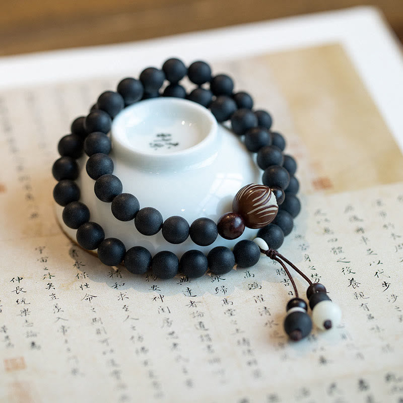 Tibetan Cypress Bodhi Lotus Bracelet - matte black mala on calligraphy with ceramic cup, healing