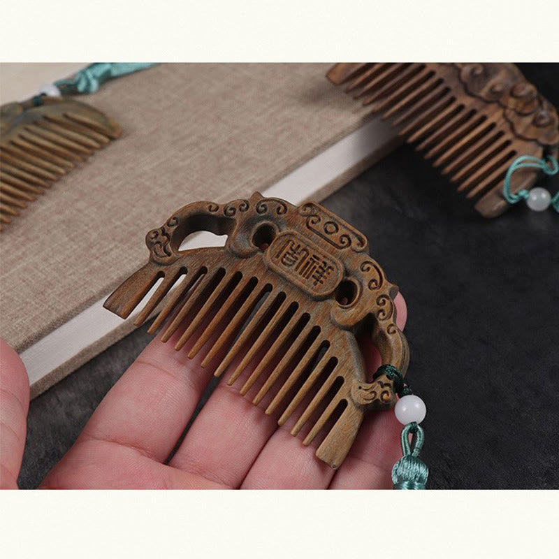 Hand holding green sandalwood auspicious cloud comb with Chinese JiXiang carving