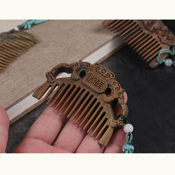 Hand holding green sandalwood auspicious cloud comb with Chinese JiXiang carving