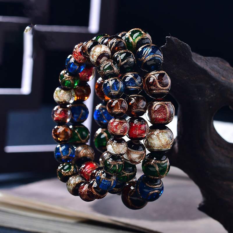 Colorful Liuli Glass Bead Luck Bracelet – Multicolor glass beads with iridescent surface hues worn on wrist with gold-tone watch, gray background lifestyle side shot