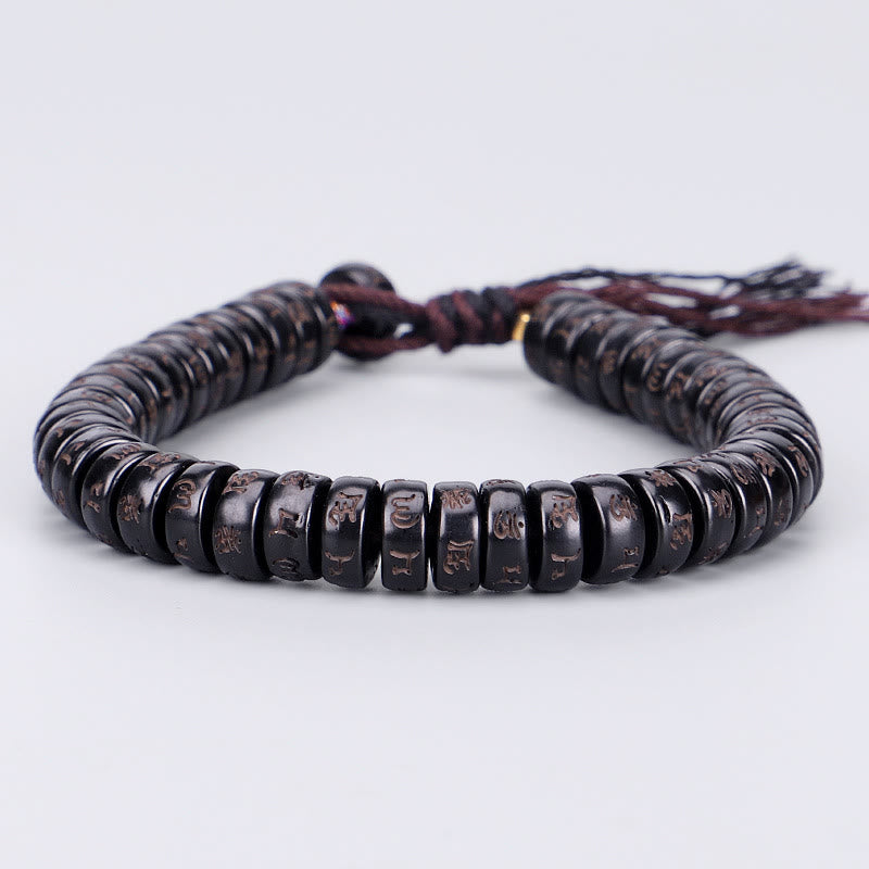 Coconut Shell Om Mani Padme Hum Bracelet – carved coconut shell mantra beads with adjustable brown cord, low front three-quarter view