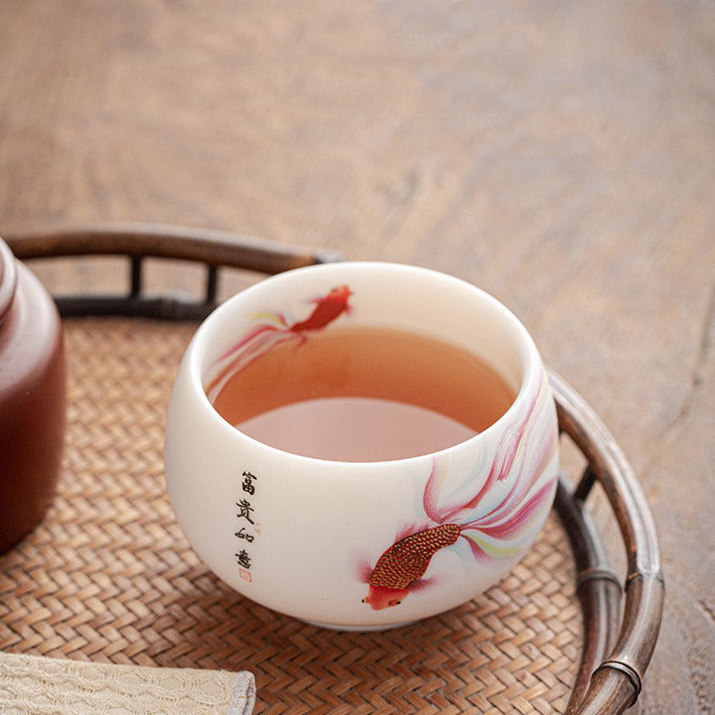 Koi Fish Ceramic Tea Cup - poured with tea showing liquid color against white interior