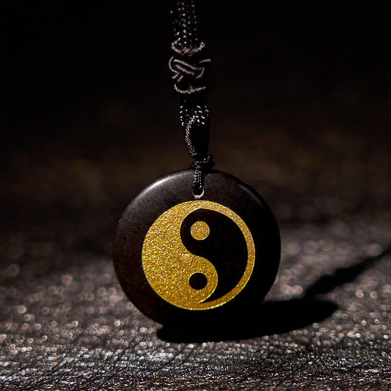 Yin Yang Crystal Necklace – Round black wooden pendant with gold yin-yang symbol on black braided cord, matte dark wood finis