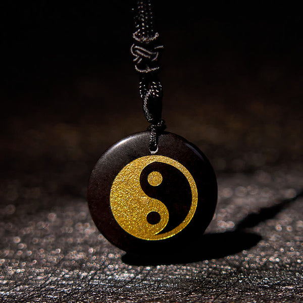 Yin Yang Crystal Necklace – Round black wooden pendant with gold yin-yang symbol on black braided cord, matte dark wood finis