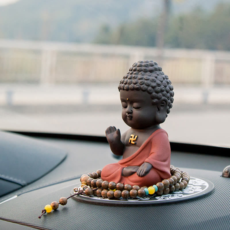 Small Buddha Purple Clay Decoration – three-quarter dashboard angle with bridge landscape bokeh, prayer bead circle, protecti