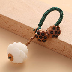 Bodhi Seed Peach Wood Lotus Keychain – Diagonal view of lotus pod charm with white stone flower and green woven cord, wooden keychain