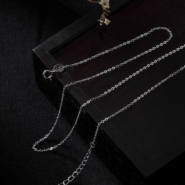 Zen Cairn Crystal Pendant – silver chain necklace with spring clasp on dark wood, minimalist chain