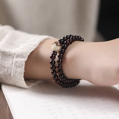 Red Sandalwood Lotus Bodhi Seed Bracelet – Triple-wrap burgundy wood beads with carved lotus accent worn on wrist
