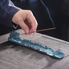 Dragon Alloy Incense Burner - Hand placing incense into turquoise dragon mouth, tranquil