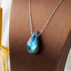 Labradorite water drop pendant necklace modeled on brown display bust showing large teardrop labradorite cabochon with electric blue labradorescence on silver chain for healing and transformation jewelry