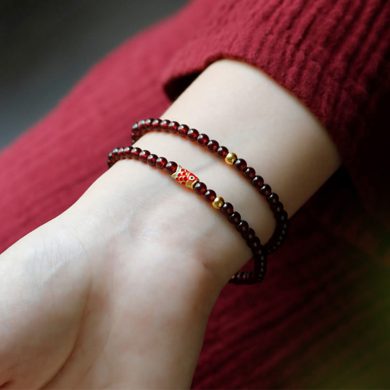 999 Gold Koi Bracelet – worn on wrist model, garnet beads, koi fish gold bracelet, lifestyle shot