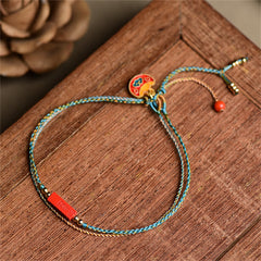 Cinnabar Braided Bracelet - Turquoise gold cord with red bead on rustic wood, bohemian bracelet