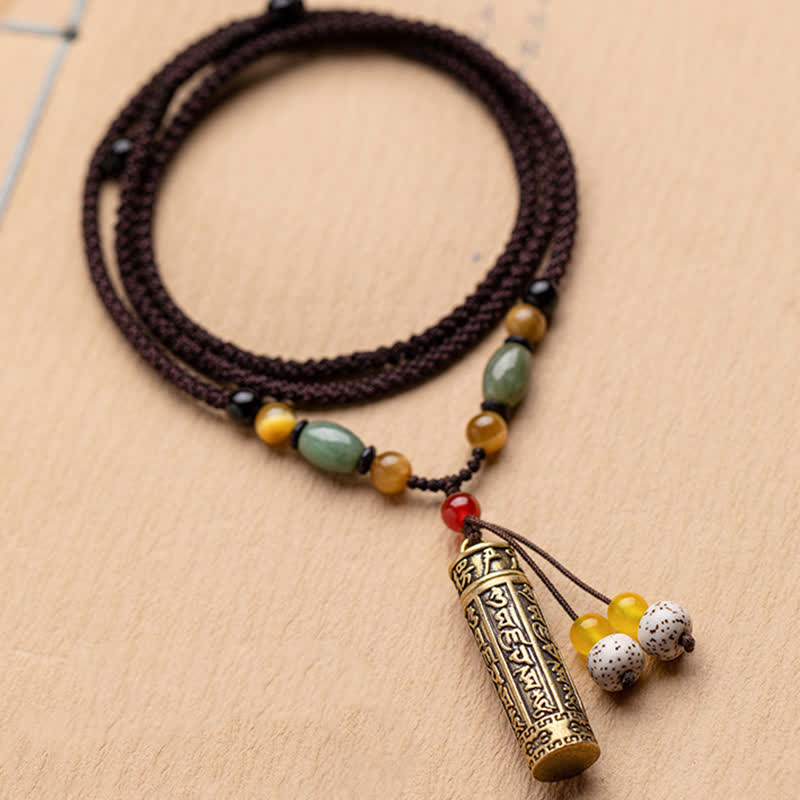 Tibetan brass cylinder pendant necklace with green jade beads on adjustable brown braided cord with bodhi seed and amber tassels