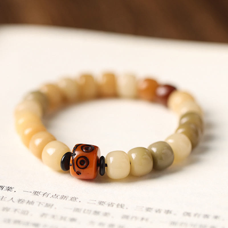 Natural Bodhi Seed Om Mani Padme Hum Wisdom Bracelet - On book page, carved bead detail