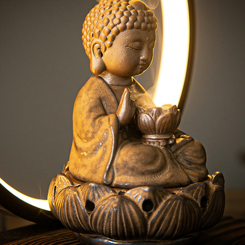 Buddha Lotus burner three-quarter profile with glowing crescent moon lamp, shallow focus, warm earth tones