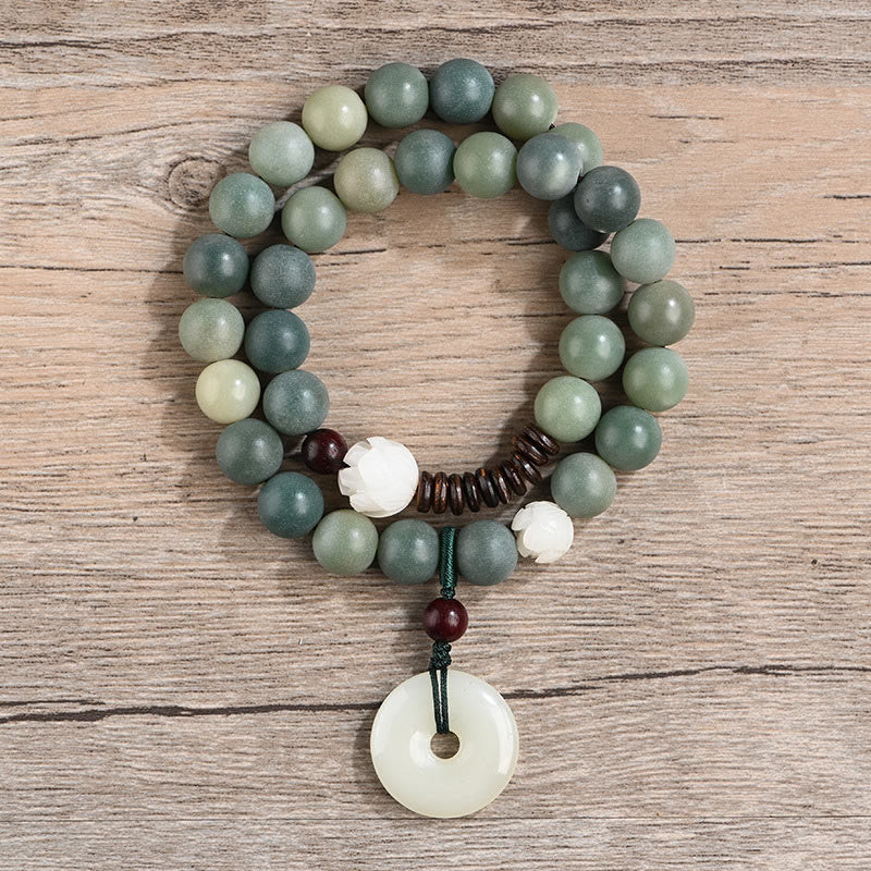 Cyan Bodhi Seed Jade Peace Buckle Bracelet - variegated green beads and white lotus carving, top-down view