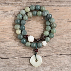 Cyan Bodhi Seed Jade Peace Buckle Bracelet - variegated green beads and white lotus carving, top-down view