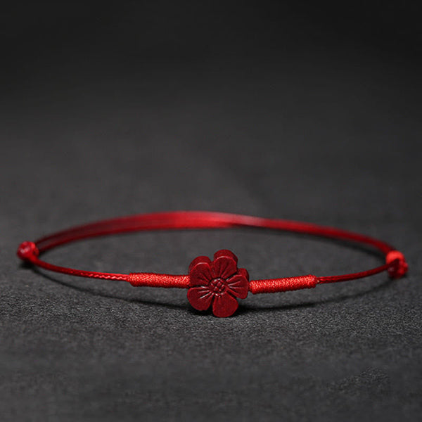 Cinnabar PiXiu Lotus Koi Fish Blessing Braid Bracelet – red cinnabar flower charm on red cord against black background, handmade lucky jewelry